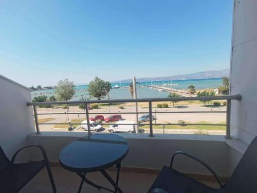 a balcony with a table and chairs and a view of the ocean at Thalassa View c2 in Khalkoútsion