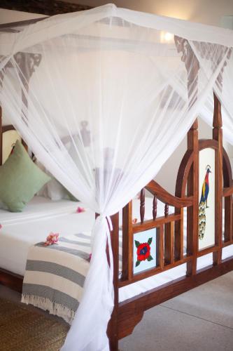 a bedroom with a bed with a canopy at Villa Juliana in Jambiani