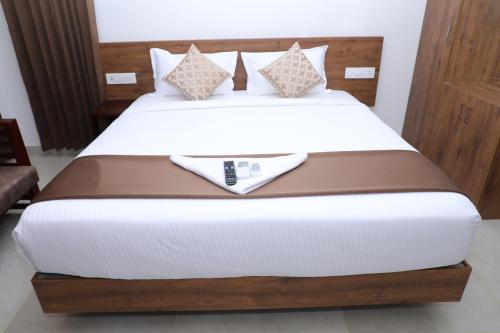 a bed with white sheets and pillows on it at Aura Airport Hotel in Nedumbassery