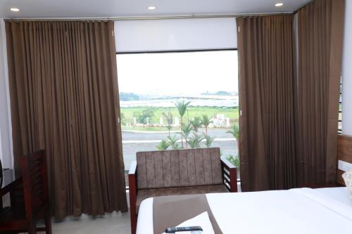 a hotel room with two beds and a large window at Aura Airport Hotel in Nedumbassery