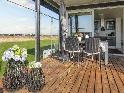 Harboørにある4 person holiday home in Harboøre-By Traumの木製デッキ(椅子、花のテーブル付)