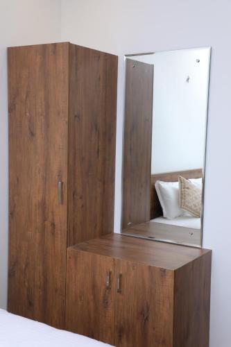 a wooden cabinet with a mirror on top of it at Aura Airport Hotel in Nedumbassery