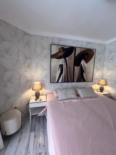 a bedroom with a bed and two tables and two lamps at SUL MARE in Puerto de Santiago