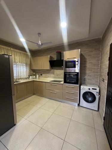 a kitchen with a washing machine and a washer at Two bedroom luxury apartment in Accra