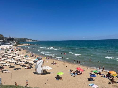 a group of people on a beach with umbrellas at ApartComplex Splendid in Saints Constantine and Helena
