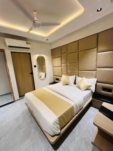a bedroom with a large bed with a large headboard at Hotel Prominent in Ahmedabad