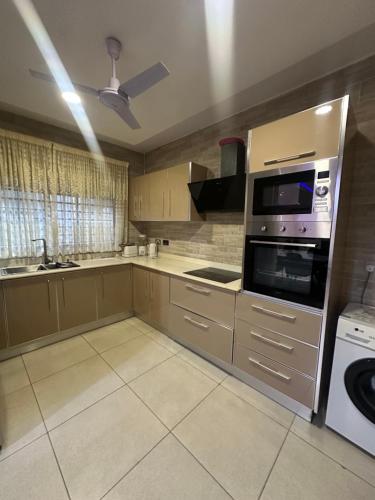 a kitchen with a stove and a microwave at Two bedroom luxury apartment in Accra