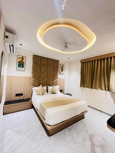 a bedroom with a large bed and a large chandelier at Hotel Prominent in Ahmedabad