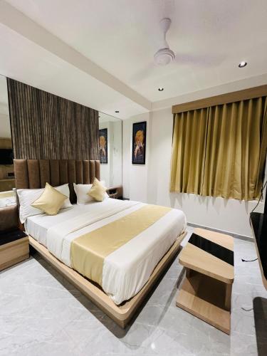 a bedroom with a large bed and a television at Hotel Prominent in Ahmedabad
