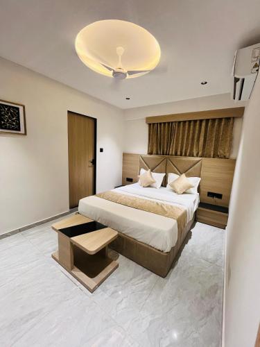 a bedroom with a large bed and a chandelier at Hotel Prominent in Ahmedabad