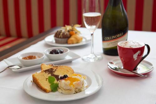a table with plates of food and a bottle of wine at The Harmonie Vienna, BW Premier Collection in Vienna