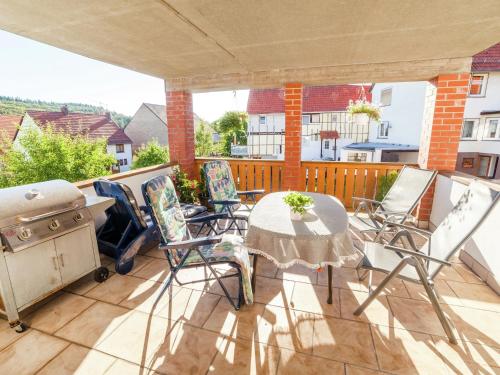 a patio with a table and chairs and a grill at Wohnung in Densberg nahe Kellerwald in Densberg