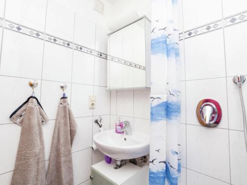 a white bathroom with a sink and a mirror at Wohnung in Densberg nahe Kellerwald in Densberg