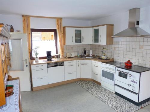 a kitchen with white cabinets and white appliances at Wohnung in Densberg nahe Kellerwald in Densberg