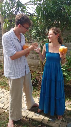 a man and a woman holding glasses of juice at Suriya Homestay in Badalgama