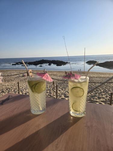 two drinks sitting on a table at the beach at Azulmaris - Direkt am Strand in Vila Chã - Terrasse und Meerblick in Vila Chã