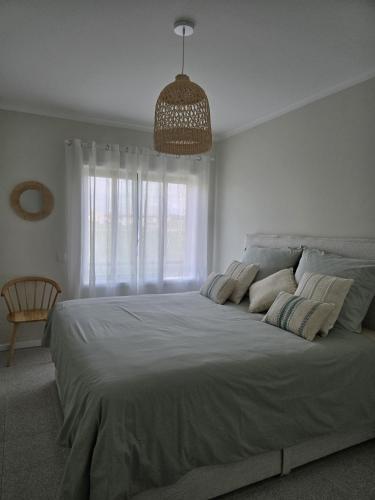 a white bedroom with a large bed with a window at Azulmaris - Direkt am Strand in Vila Chã - Terrasse und Meerblick in Vila Chã