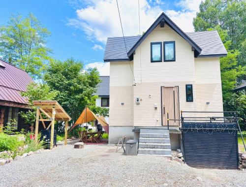 a house with a gravel driveway in front of it at Pixel Chalet.象宿.Hakuba Echoland白马滑雪避暑别墅 in Hakuba