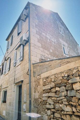 a tall brick building with a stone wall at Villa Ines in Komiža
