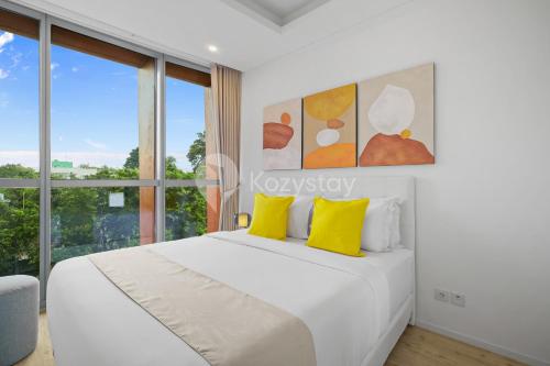 a bedroom with a white bed with yellow pillows at Soreli by Kozystay - TB Simatupang in Jakarta