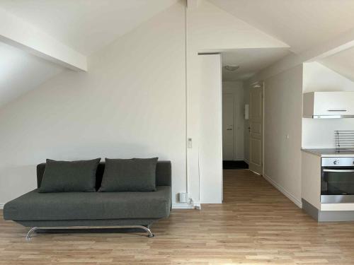 a living room with a couch and a kitchen at Central city apartment with parking space in Hjørring