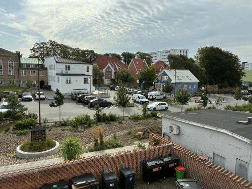 a town with cars parked in a parking lot at Central city apartment with parking space in Hjørring
