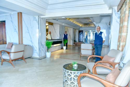 a man standing in a lobby with chairs and a table at Regency Hotel Alexandria in Alexandria