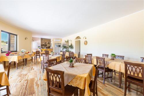 Un restaurante con mesas y sillas con mantel amarillo. en Agriturismo Cutura, en Parabita