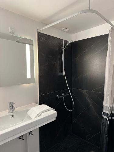 a bathroom with a shower and a sink at VISIONHOUSE Hotel in Frederikssund