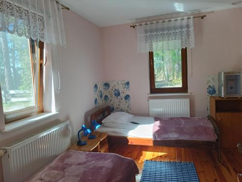 a bedroom with two beds and two windows at Noclegi, Pokoje Gościnne, Wyżywienie, Catering, AGRO ELA in Wydmusy