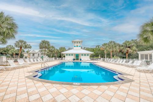 a swimming pool with chairs and a building at A Better Place in Carillon Beach
