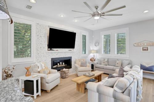 a living room with white furniture and a flat screen tv at A Better Place in Carillon Beach