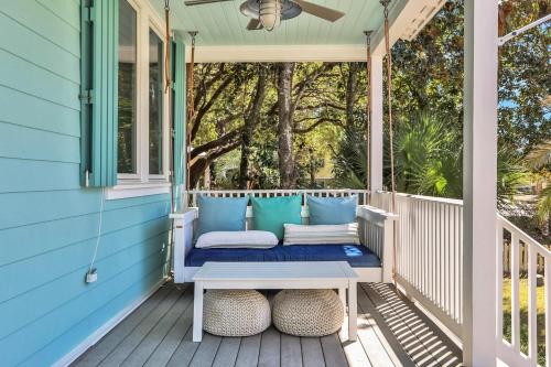 a porch with a bench on a blue house at A Better Place in Carillon Beach