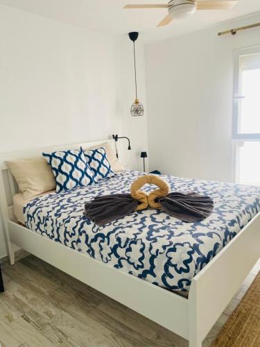 a bedroom with a bed with a blue and white comforter at TULUM MEDANO BEACH in El Médano
