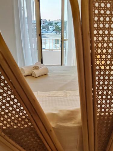 a bed with two towels sitting on the floor next to a window at Mareluna Luxury Accomodation in Lampedusa