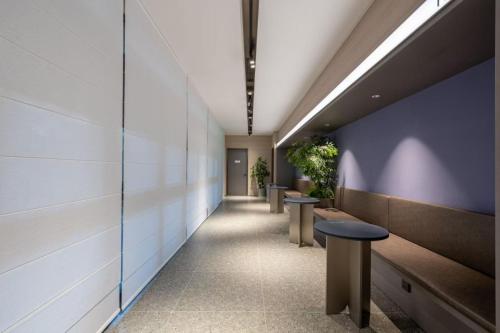 a hallway with benches and plants in a building at Atour Light Hotel Beijing Wukesong 301 PLA Hospital in Beijing