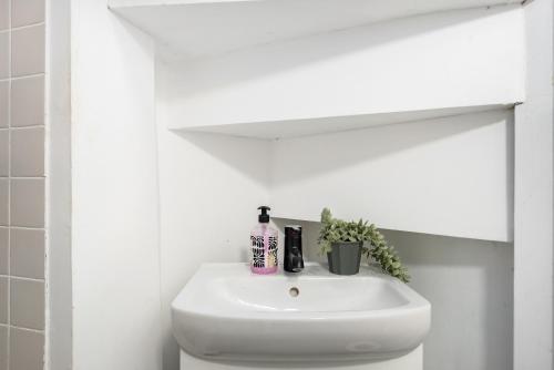 a bathroom sink with a bottle of soap on it at The Tel Hai in Tel Aviv