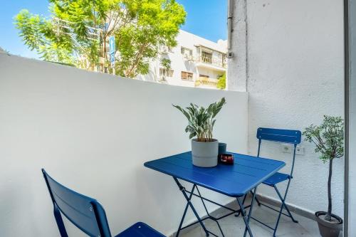 a blue table and chairs on a balcony at The Tel Hai in Tel Aviv