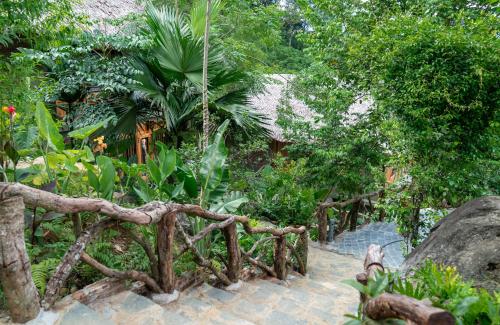 a wooden bridge in a garden with trees at Asia Tropical Resort and Spa in Làng Coc