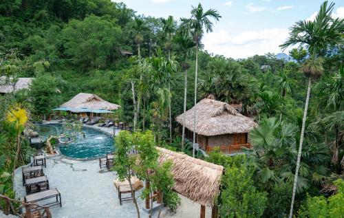 a resort with a pool and chairs and trees at Asia Tropical Resort and Spa in Làng Coc