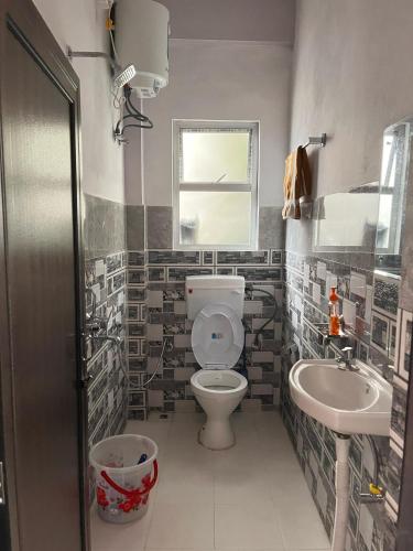 a bathroom with a toilet and a sink at Hams Cherrapunji in Cherrapunji