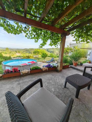 a patio with a table and chairs and a pool at Casa Aurora in Penacova