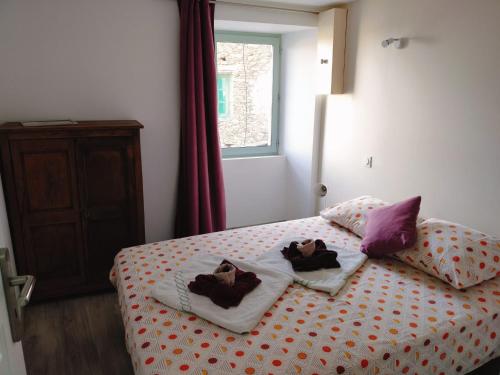 a bedroom with two towels on a bed with a window at Maison corse - cap corse in Sisco
