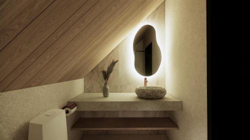 a bathroom with a sink and a mirror on a shelf at Vaattunki Wilderness Resort in Rovaniemi