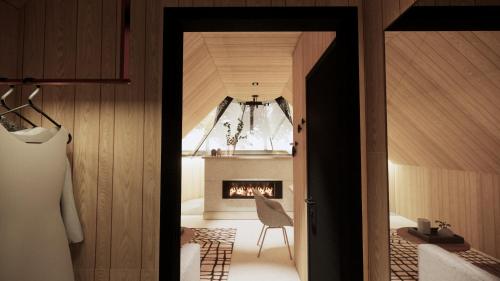 a hallway with a fireplace and a room with a chair at Vaattunki Wilderness Resort in Rovaniemi