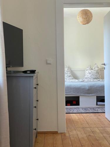 a bedroom with a bed with a television on a dresser at Ferienwohnung Utes Stube in Neuwied