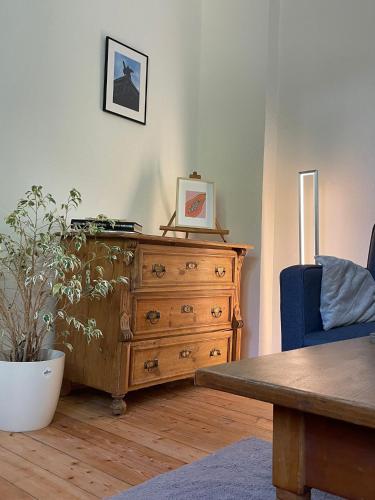 a living room with a wooden dresser and a table at Ferienwohnung Utes Stube in Neuwied