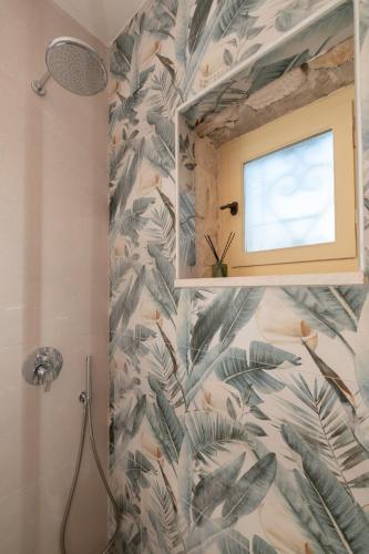 a bathroom with a shower with a tropical wallpaper at Aurum Luxury Villa Voz by elite" in Laganas