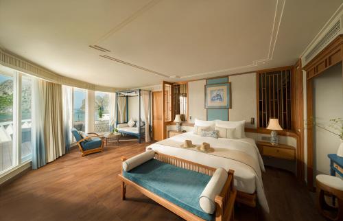 a bedroom with a large bed and a large window at Bhaya Soul Cruise in Ha Long