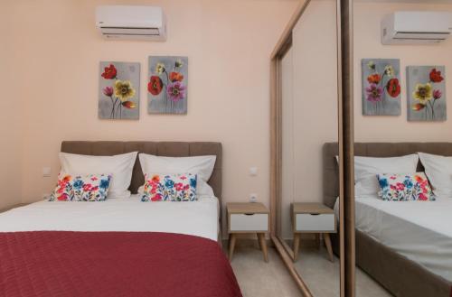 een slaapkamer met twee bedden en een spiegel bij Aurum Luxury Villa Voz by elite" in Laganas